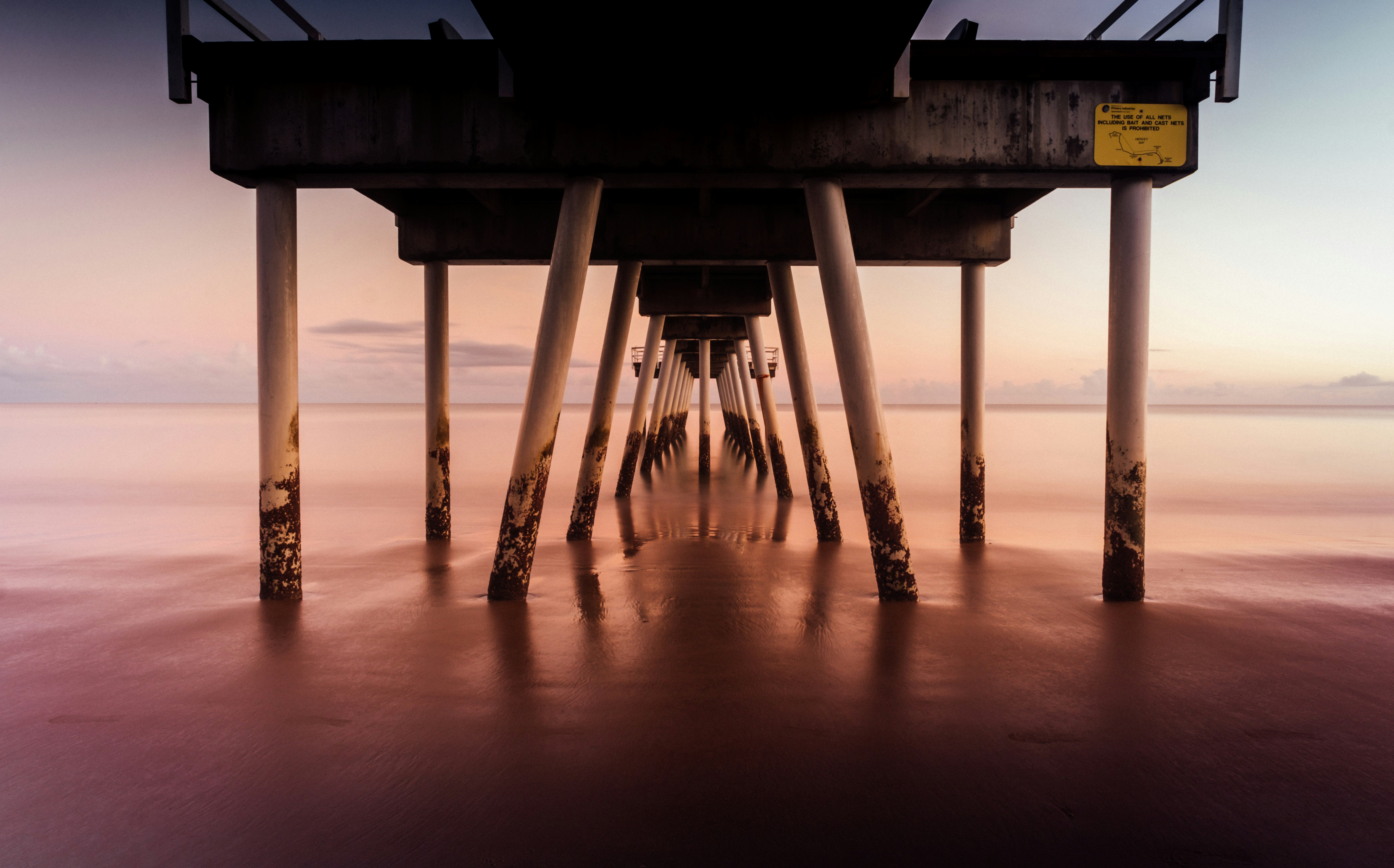 silhouette of dock on sea during sunset